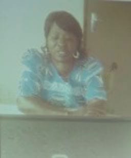A woman shown on a projection screen delivering a video message.